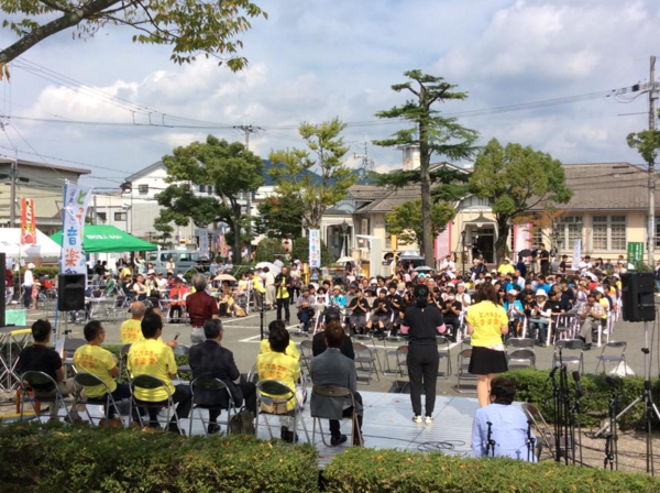 音楽祭が外で行われ晴天の中お客さんは椅子に座って聞いている写真