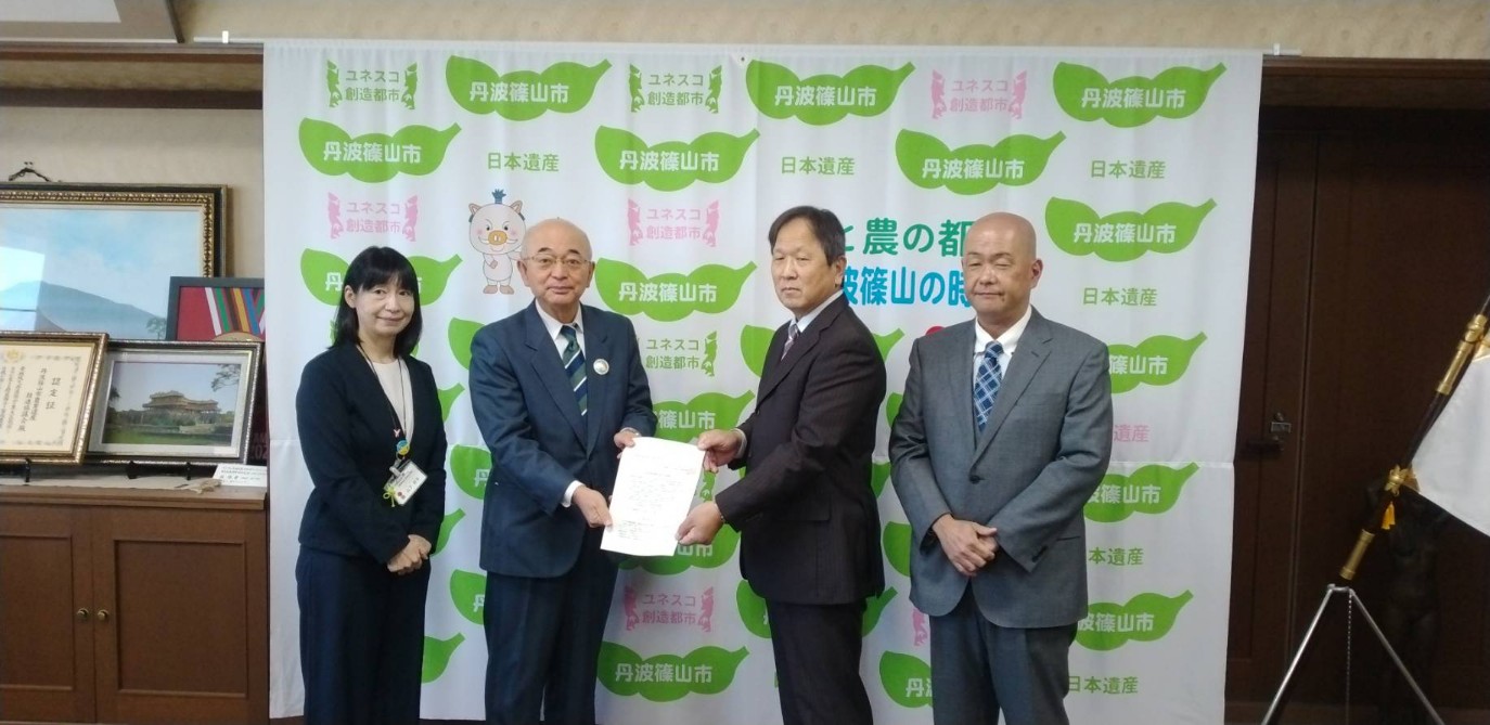 団体の代表から要望書を受け取る市長、まわりに関係者が2人立っている