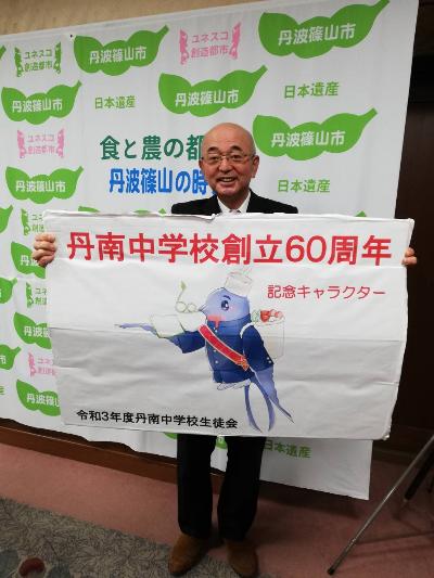 丹南中学校創立60周年という看板を持った市長