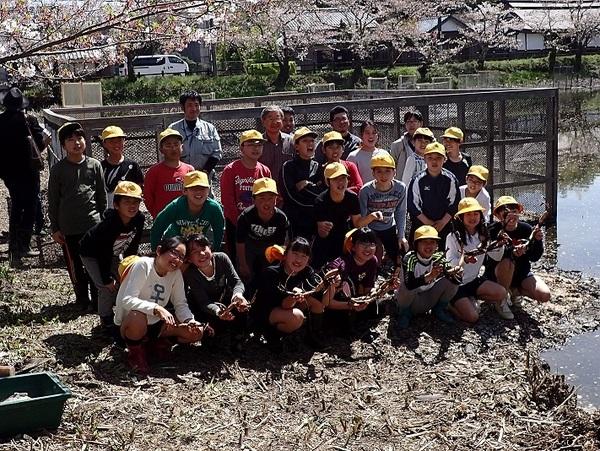 篠山城跡のお堀の横に笑顔で並ぶ小学生と関係者の集合写真