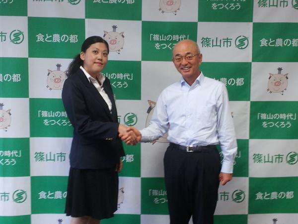 長澤 真衣子さんと市長が握手をして写っている写真