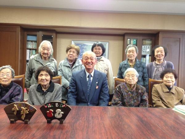 市長室でディサービスに通っている女性の皆さんの真ん中に市長が並んで笑顔で記念撮影写真