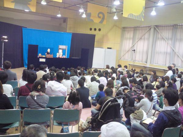 会場に来られた方が熱心に人形劇を見ている写真