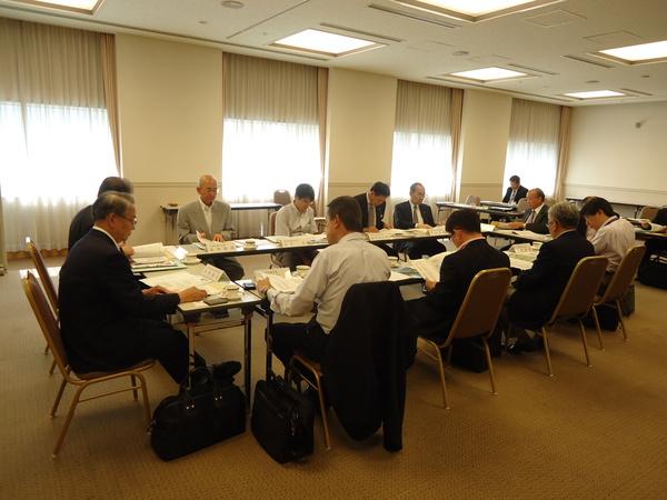 出席者が机に広げられた資料を熱心に見入っている、弁護士市長会の様子を写している写真