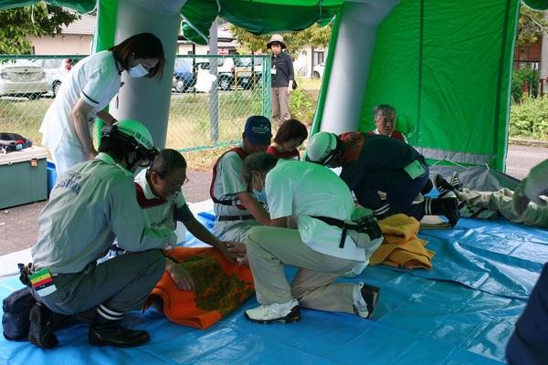 防災訓練でお医者さんや看護師さんがケガをした方の処置をしている写真