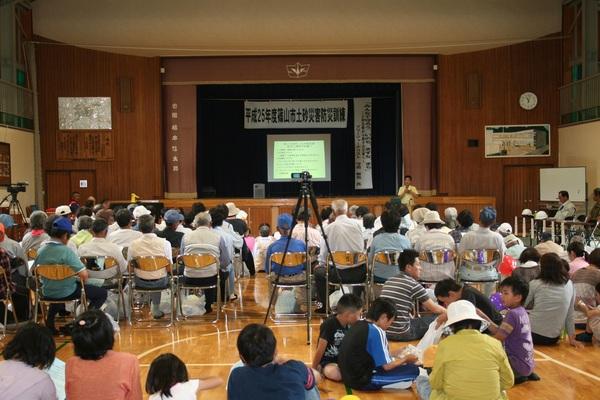 住民の方にスクリーンで災害対策の説明をしている写真