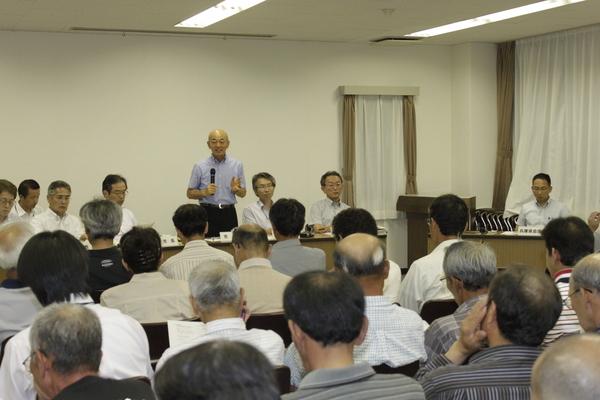 ふるさと一番会議にて、市長が立って話をしていて、大勢の方が聞いている写真