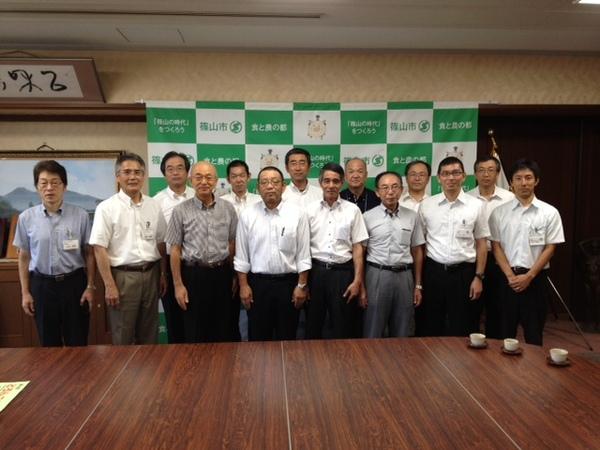 応接室の机の前に並ぶ市長と愛媛県愛南町の関係者の男性方の集合写真