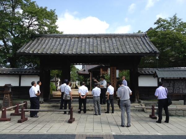 歴史美術館の入り口で関係者の男性たちが説明を聞いている写真