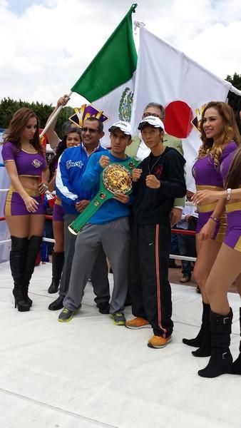 リング上でスタッフとチャンピオンと共に記念写真を撮っている角谷選手の写真