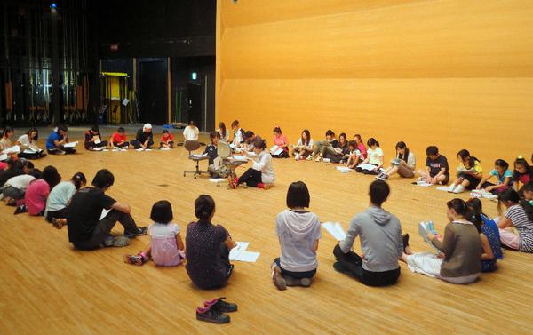 皆で円になり、円の中心で2名の方が資料を見ながら説明している写真