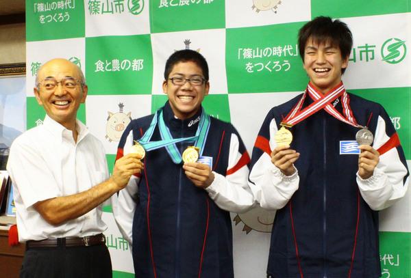 溝畑 樹蘭君、野々口 慎也君がメダルを首にかけ市長と笑顔で記念写真