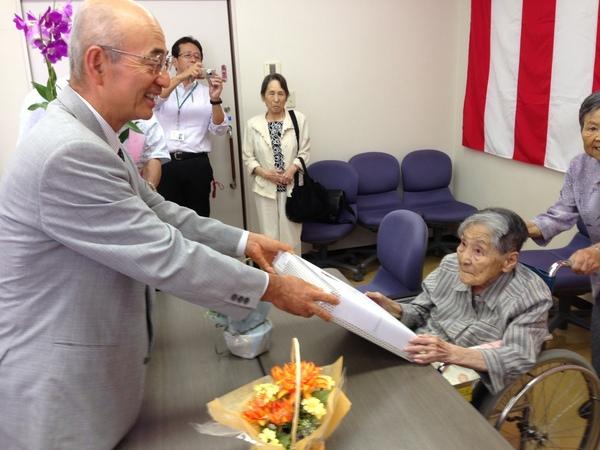 酒井 志づ子さんが市長から記念品を受け取っている写真