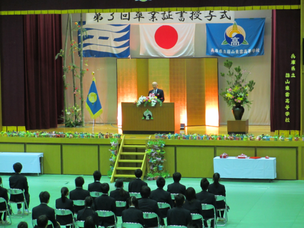 市長が舞台の上で卒業生にお話ししている写真