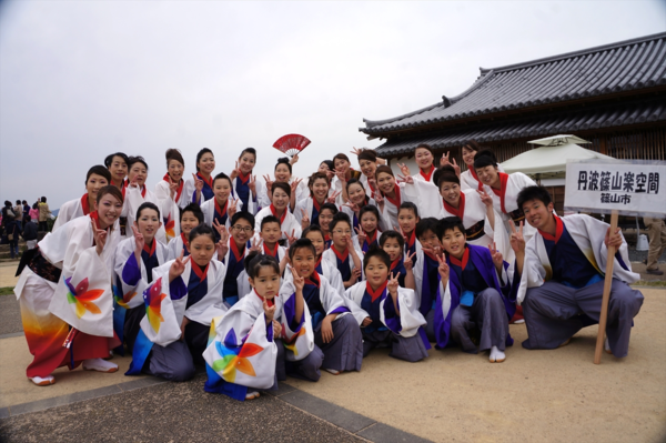 白地に袖に大きくカラフルな色のもみじの様な柄をつけた着物を着た男女混合のチーム「丹波篠山楽空間」のメンバーの集合写真