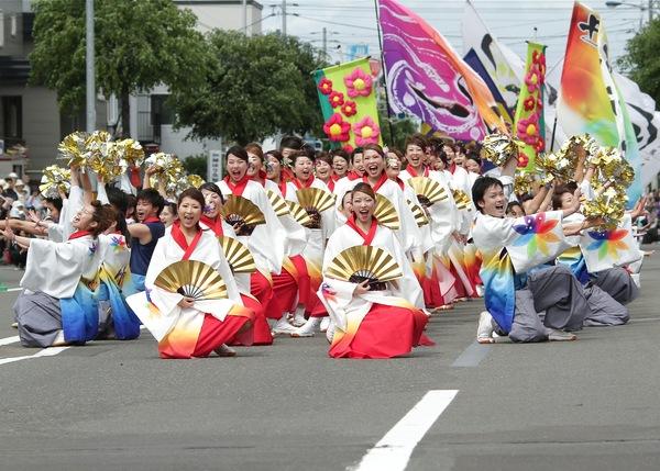 金色のポンポンを持っている人達、金色の扇子を持っている人たちが、片膝をつきポーズをとっている丹波篠山楽空間一期一会の皆さんの写真