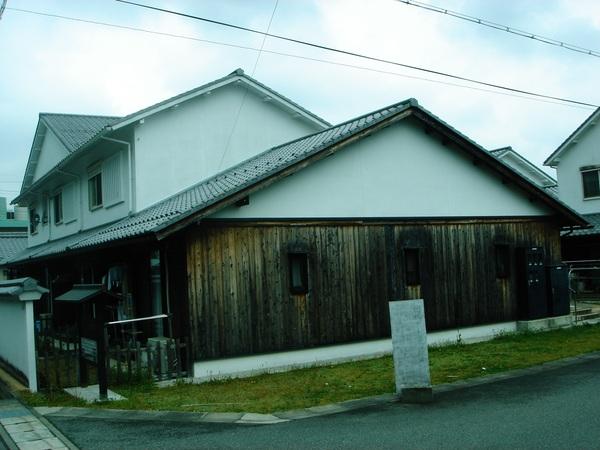 大きな建物が一軒あり、その建物の外壁の色あせが進んでいる写真