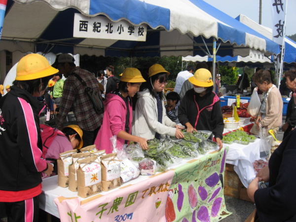 味覚フェア楽市楽座にて、小学生が黒豆や米を販売している写真