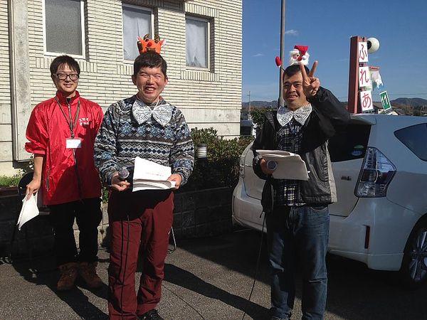 頭にサンタの人形を被ってピース、もう一人はトナカイの人形の帽子を被って笑顔で記念写真