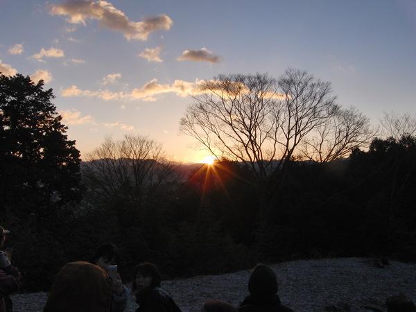 朝日が昇り始め山や木々を照らしている写真