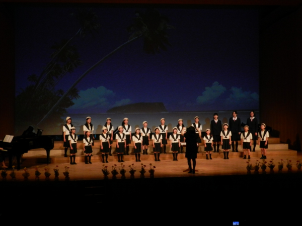 篠山少年少女合唱団第39回リサイタルで23名の子供たちが舞台の上で合唱している写真