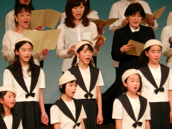 合唱団の方と子供達で一緒に合唱している写真
