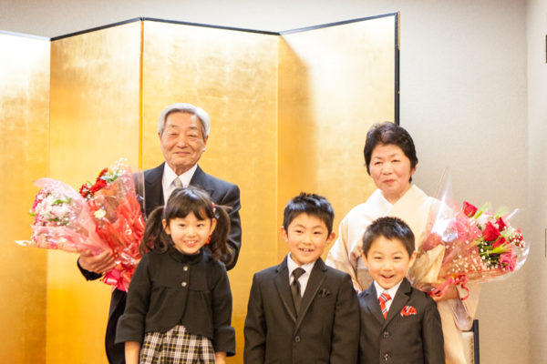 市野 勝さんとご家族で花束を持っている写真