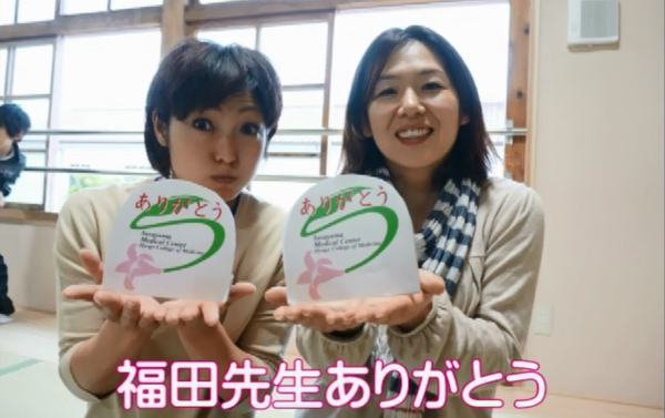 女性2人が「ありがとう」のメッセージカードを顔の前に近づけて写っている写真