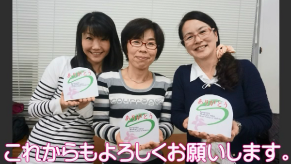 女性3人が笑顔でメッセージカードを持って写っている写真