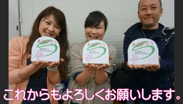 女性2人と男性1人でメッセージカードを持って笑顔で写っている写真