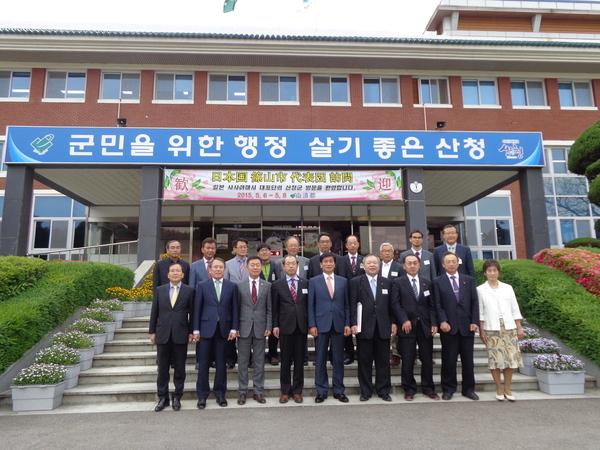 10名の篠山市訪問団が山清郡の職員らと一緒に山清郡庁前で記念撮影している写真