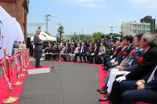 沢山の人々が座っていてその真ん中にはデヴィ夫人が座られている、その前で挨拶をされる男性の写真