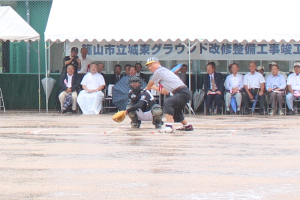 市長が腰を落としてバットを振りかぶっている写真