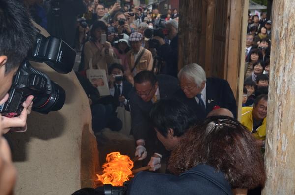 市野組合長、谷代議士、井戸知事3名で窯の火入れが行われている所を大勢の人たちが見ている写真