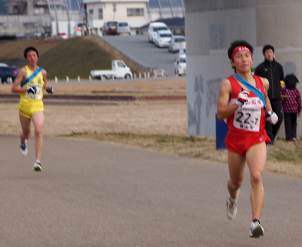 清水 翼君が、黄色いユニホームを着た選手の前を走っている写真