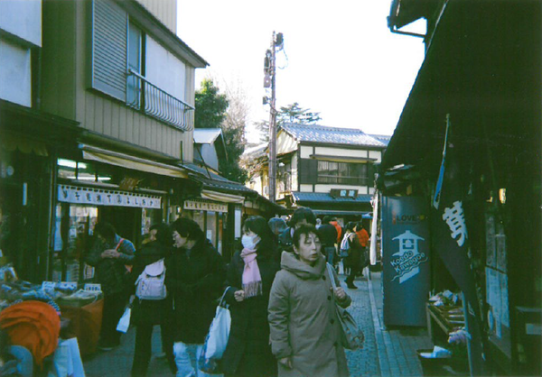 商店街の街並みを沢山の人が歩いている写真