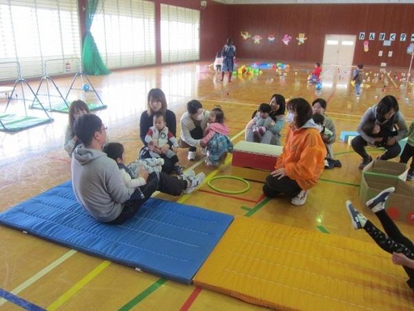 体育館にマットや跳び箱があり親子で遊びに参加している写真