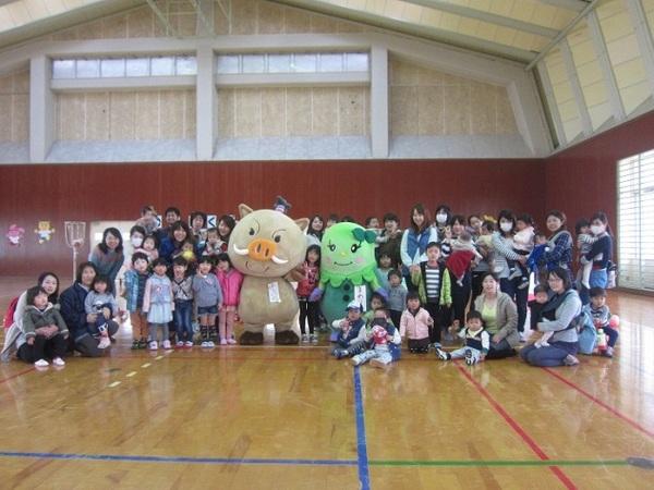 体育館にてゆるキャラ2体を中央にわんぱくデーに参加した親子たちの集合写真