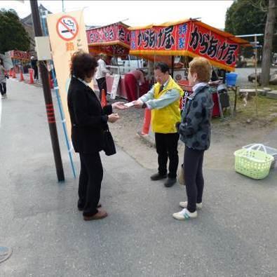 屋台前で路上喫煙禁止のティッシュを配っている写真