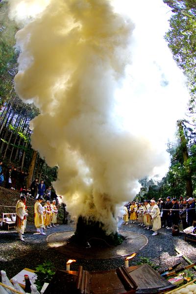 白装束を着た修行僧の人達が囲んだ護摩焚きの煙がモクモクしている様子を市民が後ろで見守っている創造農村まちづくり賞受賞の写真