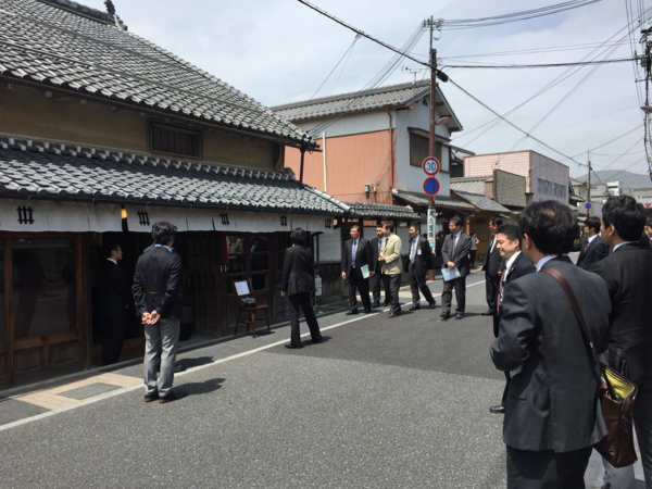 丹波篠山城下町ホテルNIPPONIAの入り口前に集まる、スーツ姿の大勢の関係者の写真
