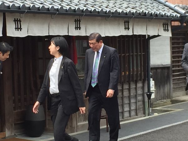 地方創生担当の石破大臣と、その横を歩くスーツの女性の写真