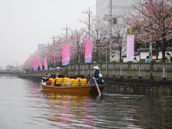 黄色のライフジャケットを身に着けてボートに乗って川を渡っている写真