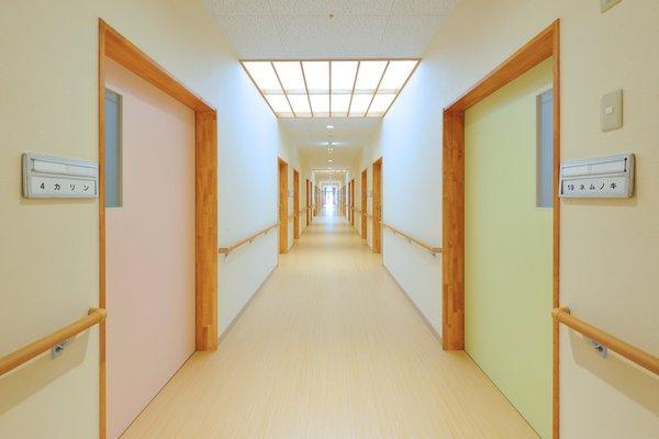 両脇に各部屋が並ぶ長い廊下を写した写真