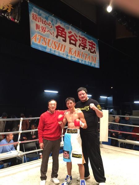 赤いセーターの男性と角谷選手、黒いTシャツの男性,3人がリンクの上でガッツポーズをしている写真