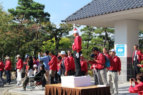 スターター台に乗った男性がピストルを持った右手を高くあげている写真