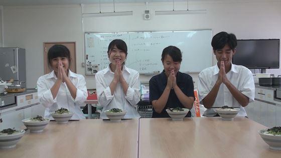家庭科室の机に丼が並べられていて、高校生4名が合掌している写真
