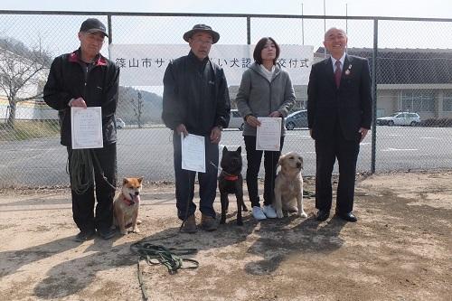 市長と犬を連れて表彰状を持った男性2人と女性1人が並んでいる写真