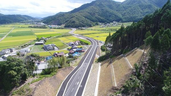山々に囲まれ田園風景が広がる丹南バイパスを空から写した写真