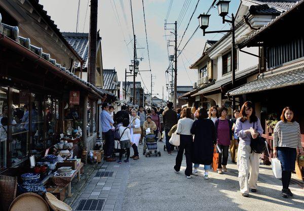骨董品などがある町屋通りを歩いている人々の写真
